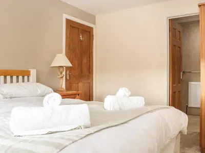 a bedroom with two beds with towels on them at Maple in Falmouth