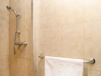 a shower with a white towel hanging on a wall at Maple in Falmouth