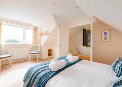 a bedroom with a large bed and a bath tub at Silverdale in Wadebridge