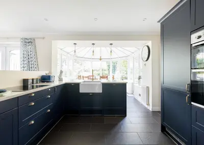 a kitchen with blue cabinets and a sink at Silverdale in Wadebridge