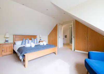 a bedroom with a bed and a blue couch at Silverdale in Wadebridge