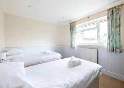 two beds in a room with a window at Silverdale in Wadebridge