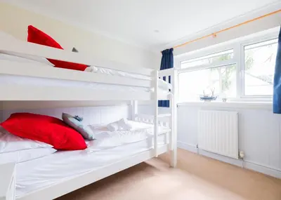 a bedroom with two bunk beds with red pillows at Silverdale in Wadebridge