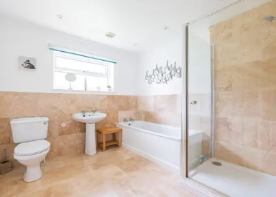 a bathroom with a toilet and a tub and a sink at Silverdale in Wadebridge