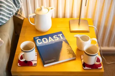 a table with a book and cups on it at Pencreek in Padstow