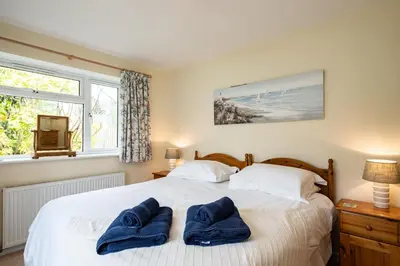 a bedroom with a bed with two blue towels on it at Pencreek in Padstow