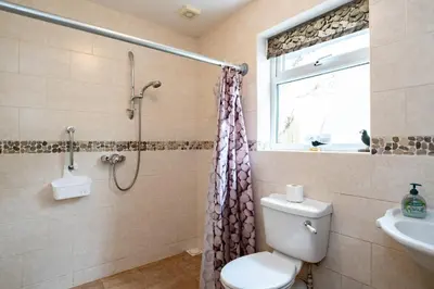 a bathroom with a shower and a toilet and a sink at Pencreek in Padstow