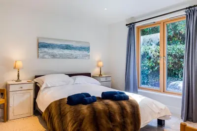 a bedroom with a bed with two blue towels on it at Greystones Studio in Polzeath