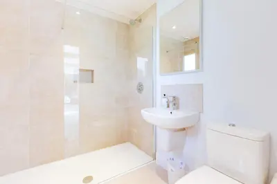 a bathroom with a shower and a toilet and a sink at Greystones Studio in Polzeath