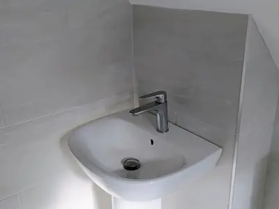a white sink in a white walled bathroom at Chy-An-Var in Polzeath