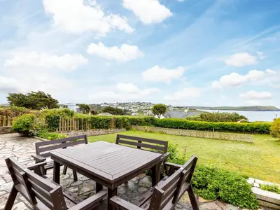 a wooden table and two benches sitting on a patio at Chy-An-Var in Polzeath