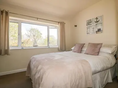a bedroom with a large bed and a window at 49 Atlantic Reach in Newquay