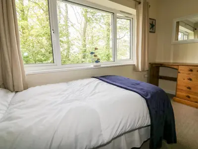 a bedroom with a bed and a large window at 49 Atlantic Reach in Newquay