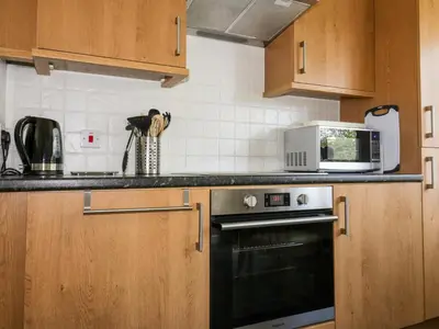 a kitchen with a microwave and a stove at 49 Atlantic Reach in Newquay