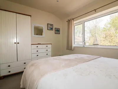 a bedroom with a white bed and a window at 49 Atlantic Reach in Newquay