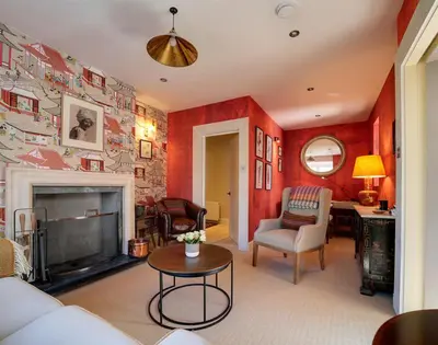a living room with red walls and a fireplace at Trevanion in Saint Minver
