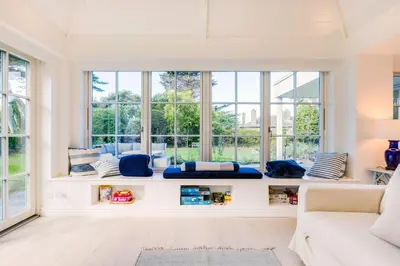 a living room with windows and a white couch at Greystones in Polzeath