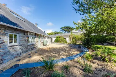 a stone house with a stone pathway leading to a yard at Greystones in Polzeath