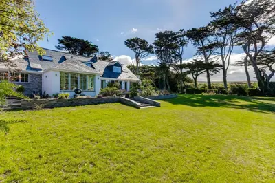 a white house with a large yard at Greystones in Polzeath