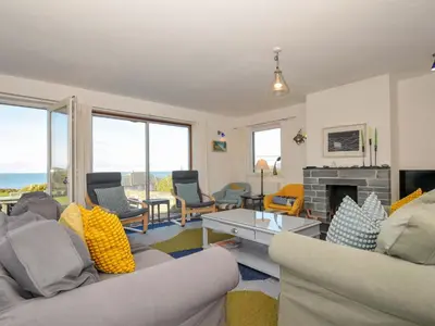a living room with two couches and a fireplace at Upper Gren in Polzeath