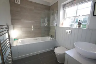 a bathroom with a tub and a toilet and a sink at Westray House in Polzeath