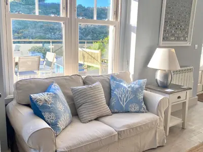 a living room with a couch with blue and white pillows at Westray House in Polzeath