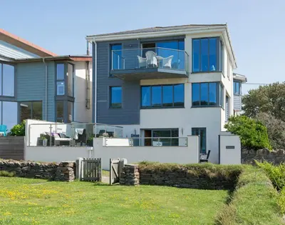 a large house with a white dog on a balcony at Egloskerry in Wadebridge