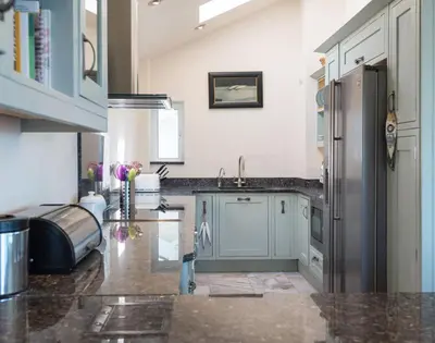 a kitchen with a stainless steel refrigerator and a sink at Egloskerry in Wadebridge