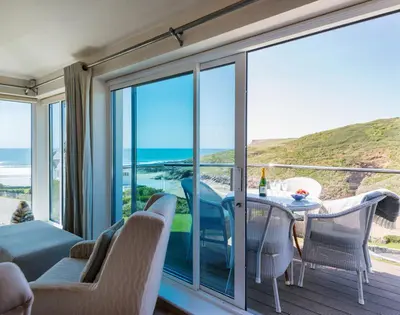 a room with a balcony with a table and chairs at Egloskerry in Wadebridge