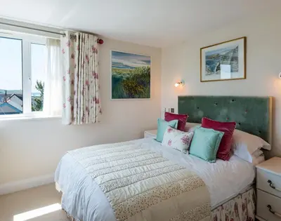 a bedroom with a large bed with colorful pillows at Egloskerry in Wadebridge