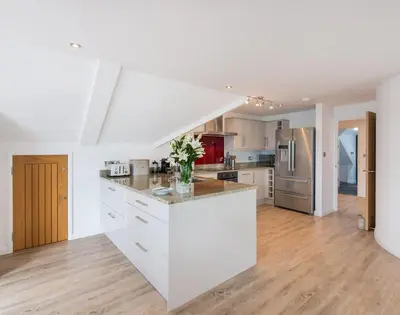 a large kitchen with white cabinets and a counter top at Upper Deck in Padstow