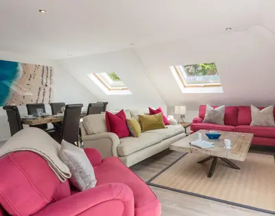a living room with couches and tables and windows at Upper Deck in Padstow