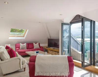 a living room with red furniture and a balcony at Upper Deck in Padstow