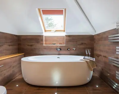 a large white tub in a bathroom with a window at Upper Deck in Padstow