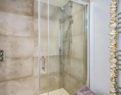 a shower with a glass door in a bathroom at Seastar in Wadebridge