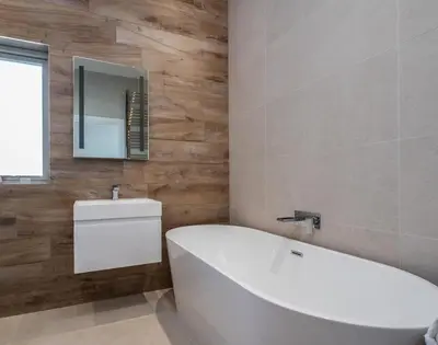 a bathroom with a white tub and a mirror at Seastar in Wadebridge