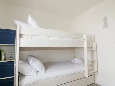 a white bunk bed with white pillows on it at Gwel Nans in St. Agnes
