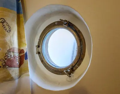 a small window in a white bowl on a table at Coppingers Cottage in Polzeath