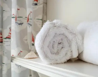 a pile of towels sitting on a shelf at Coppingers Cottage in Polzeath