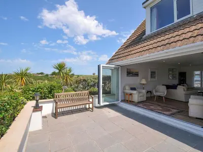 a house with a patio with a bench at Sunset in Polzeath