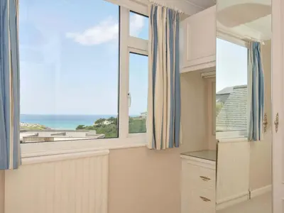 a kitchen with a window with a view of the ocean at Sunset in Polzeath
