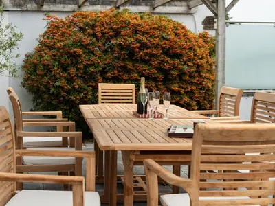 a wooden table and chairs with wine glasses on it at Little Strand in Padstow