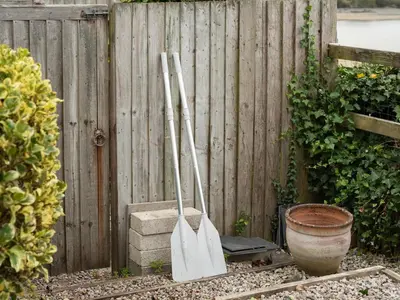 two baseball bats and a pot next to a fence at Little Strand in Padstow