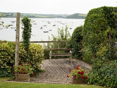 a bench sitting on a boardwalk next to a body of water at Little Strand in Padstow