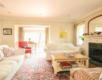 a living room with white couches and a fireplace at Little Strand in Padstow