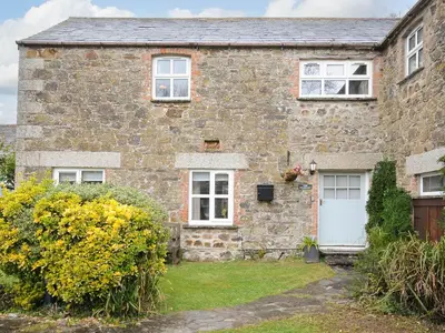 an old stone house with a white door at The Granary in Saint Minver