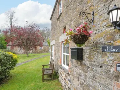 a stone building with a window and a sign on it at The Granary in Saint Minver