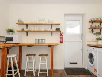 a kitchen with a counter and two stools at Trevega in Polzeath