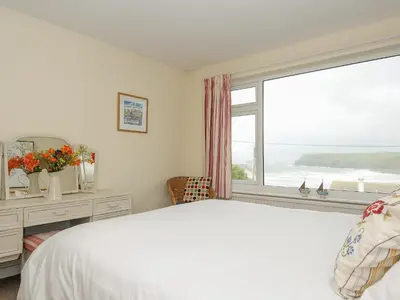 a bedroom with a bed and a large window at Trevega in Polzeath
