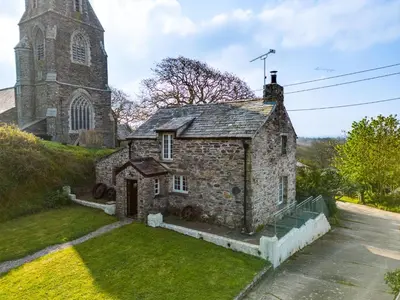 an old stone church with a tower on a hill at Dingles Cottage in Saint Minver